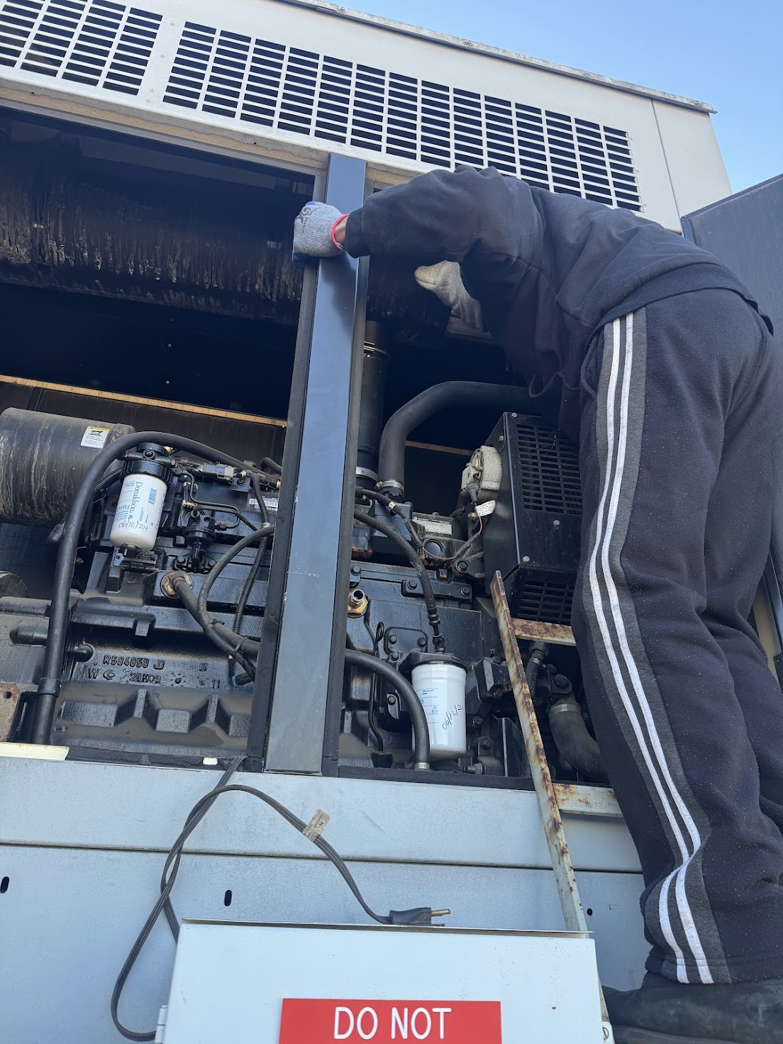 Technician servicing large generator